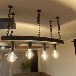 Dizajnové svietidlo nad jedálenským stolom ako súčasť osvetlenia navrhnutého a vyrobeného na mieru