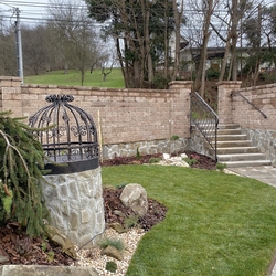 Forged well cover and railing in the garden of a family home