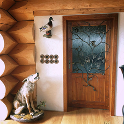 Výnimočná ručne kovaná mreža s dubovým motívom na dverách poľovníckej chaty