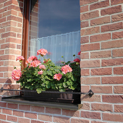 Jednoduchý kovaný držiak kvetináčov na okne rodinného domu