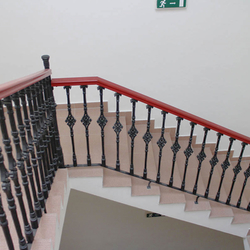 Cast iron railings with a wooden handrail in a historic house from the 16th century
