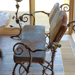 Umelecká lavička s kožou vykovaná v umeleckom kováčstve UKOVMI ako súčasť jedálenského nábytku