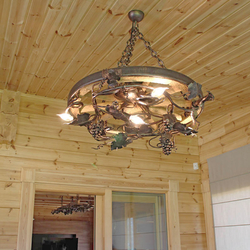 Stylish chandelier in enclosed summer house in mountain cottage – hand-wrought iron work of art with an UKOVMI seal