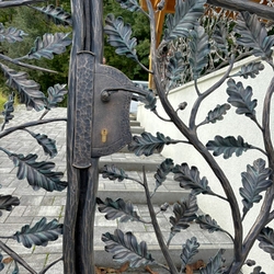 Detail of a forged gate with oak branches  designer fencing