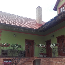 Pohľad na rodinný dom s kovaným prístreškom a zábradliami s dubovým vzorom vyrobenými v UKOVMI
