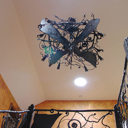 A wrought iron bat above a gallery - an eye-catching chandelier