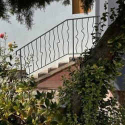 Modern wrought iron railing on the stairs at the entrance to the family house - outdoor railing