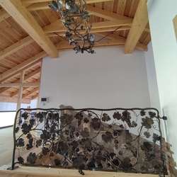 A hand forged lighting – A vine growing around a ladder in a family home in Moravia